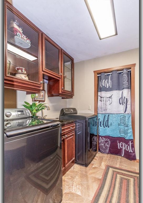 clothes washing area with cabinet space and washer and clothes dryer