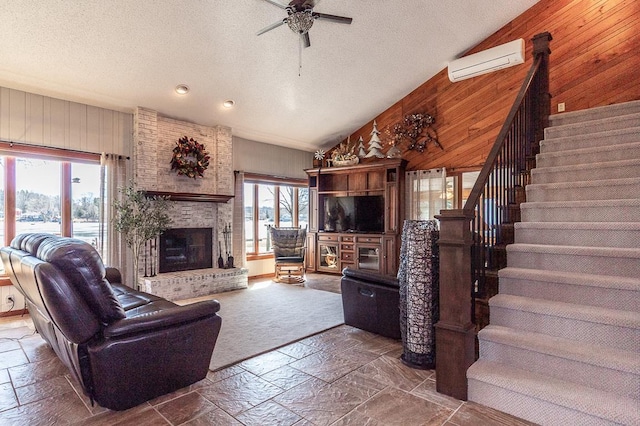 living room with lofted ceiling, wooden walls, stone tile flooring, and a wall unit AC