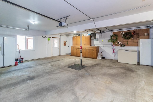 garage featuring a garage door opener, white refrigerator with ice dispenser, freestanding refrigerator, and fridge