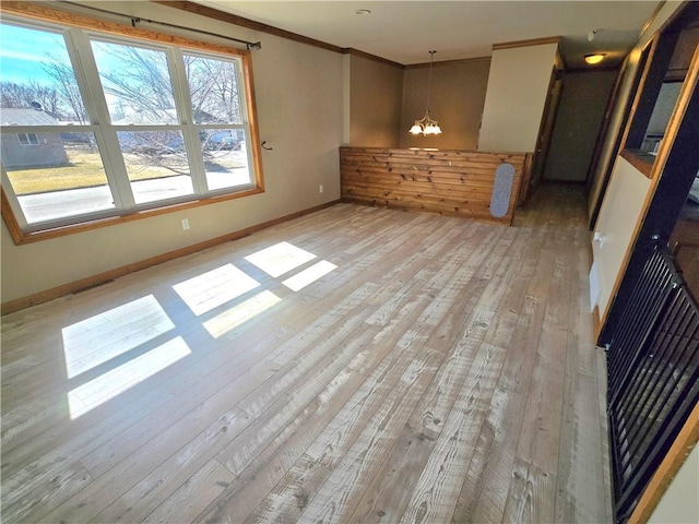 interior space with visible vents, crown molding, baseboards, a chandelier, and light wood-type flooring