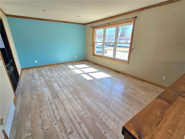 unfurnished living room with light wood-style flooring, baseboards, and ornamental molding