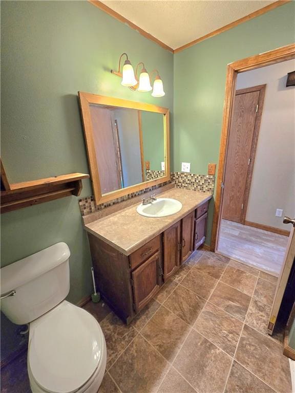 bathroom featuring toilet, a textured ceiling, tasteful backsplash, crown molding, and vanity