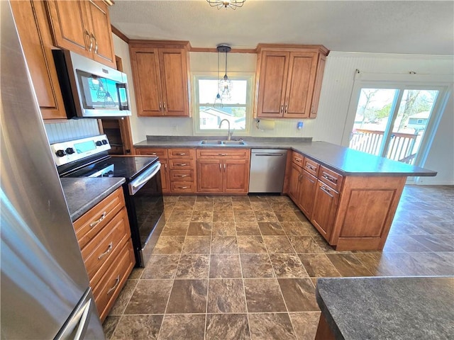 kitchen with a sink, appliances with stainless steel finishes, a peninsula, and brown cabinetry