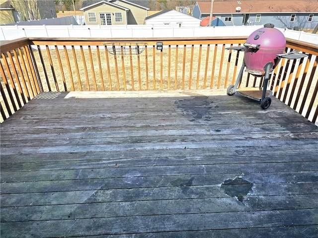 wooden terrace featuring a fenced backyard and a lawn