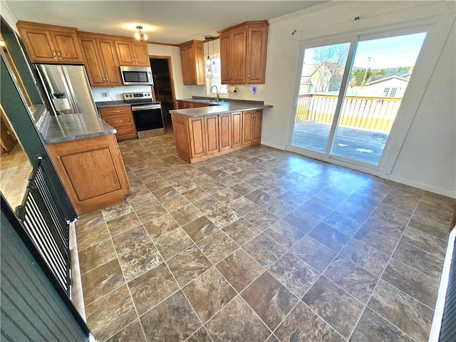 kitchen featuring brown cabinets, ornamental molding, a sink, appliances with stainless steel finishes, and a peninsula