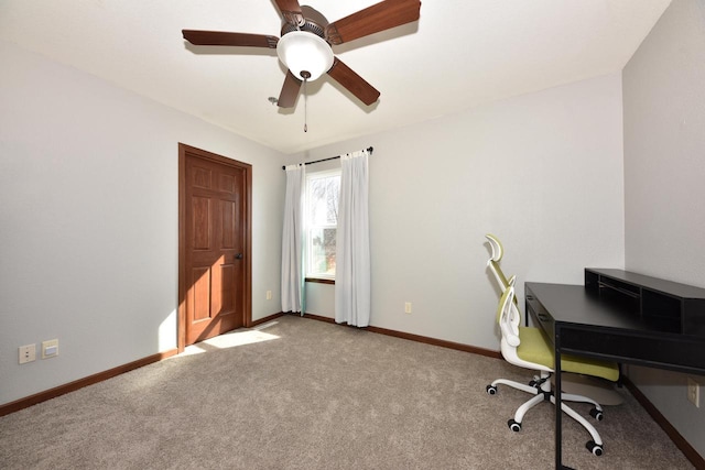 carpeted office featuring baseboards and a ceiling fan