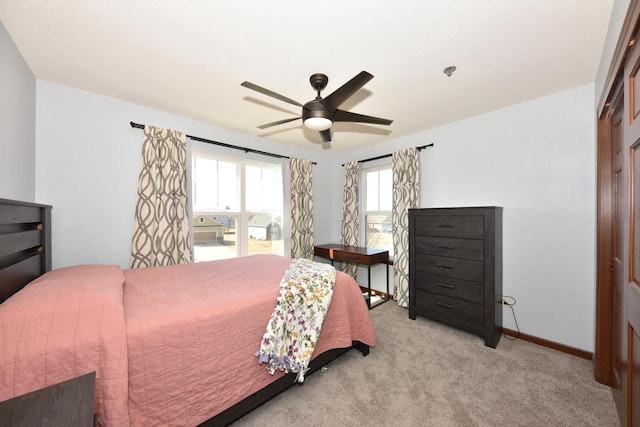 bedroom with a ceiling fan, light colored carpet, and baseboards