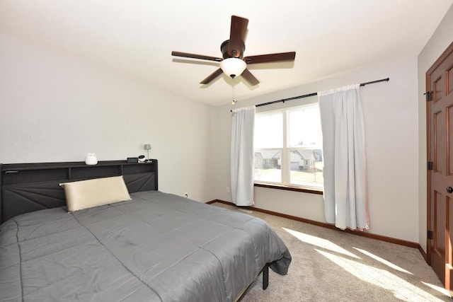 carpeted bedroom featuring baseboards and ceiling fan