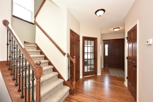 entryway featuring stairs, baseboards, and wood finished floors