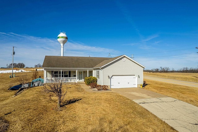 single story home featuring a garage, covered porch, driveway, and a front yard