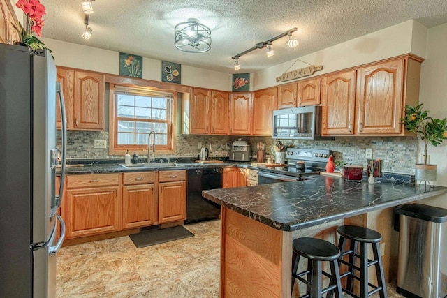 kitchen featuring a breakfast bar area, decorative backsplash, a peninsula, stainless steel appliances, and a sink