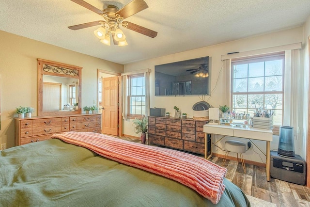 bedroom with a textured ceiling, ceiling fan, and wood finished floors