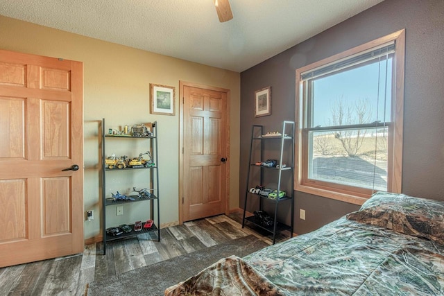 bedroom featuring a textured ceiling, a ceiling fan, and wood finished floors