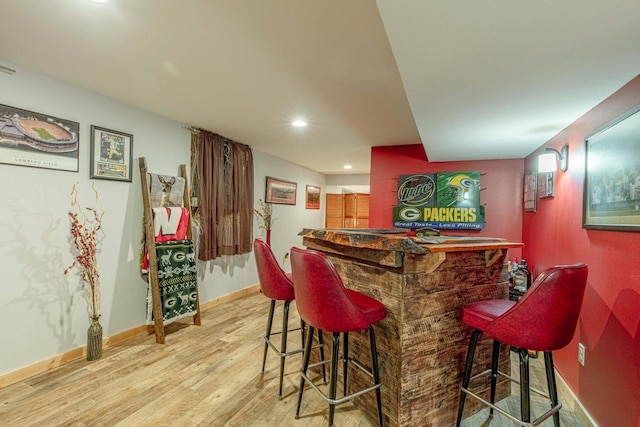 bar featuring a dry bar, recessed lighting, wood finished floors, and baseboards