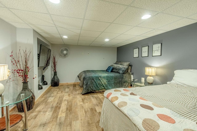 bedroom featuring recessed lighting, light wood-style flooring, a paneled ceiling, and baseboards