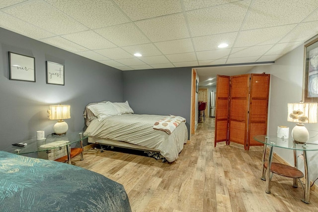 bedroom with wood finished floors and a drop ceiling