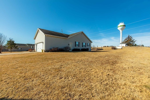 view of side of home featuring a lawn and an attached garage