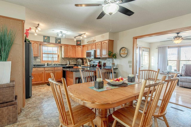 dining room featuring visible vents, a textured ceiling, and a ceiling fan