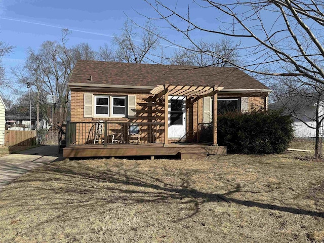 bungalow-style house featuring a shingled roof, brick siding, a deck, and a pergola