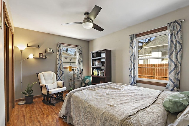 bedroom with a ceiling fan, baseboards, and wood finished floors