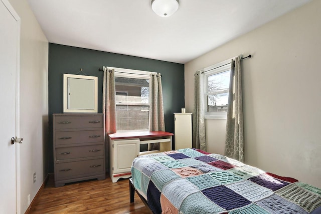 bedroom with baseboards and wood finished floors