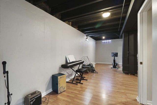 basement with baseboards and wood finished floors