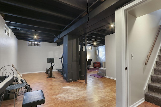 workout area with baseboards and wood finished floors