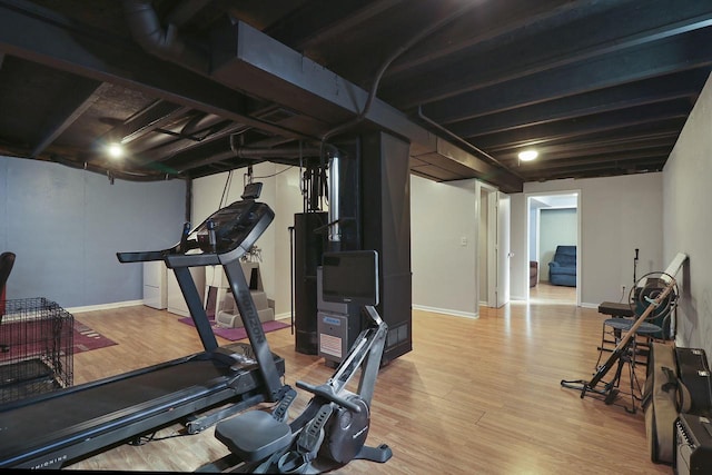 workout area with baseboards and wood finished floors