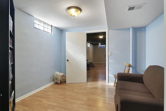 sitting room with light wood-type flooring, visible vents, and baseboards