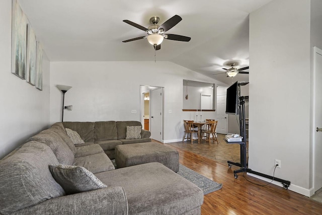 living room with baseboards, wood finished floors, a ceiling fan, and vaulted ceiling