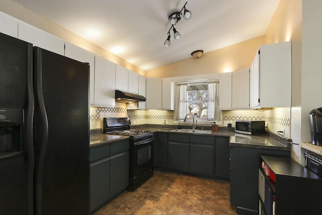 kitchen with under cabinet range hood, vaulted ceiling, decorative backsplash, black appliances, and a sink