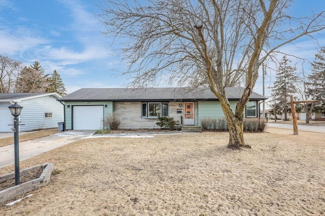 single story home with concrete driveway, a garage, and roof with shingles