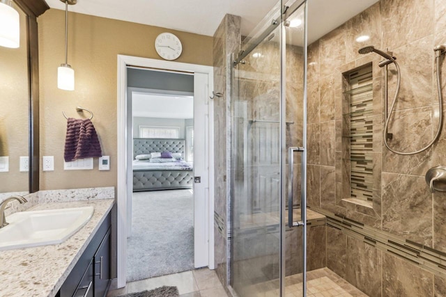 ensuite bathroom with tile patterned flooring, a shower stall, vanity, and ensuite bathroom