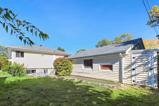 rear view of property with a lawn and an outdoor structure