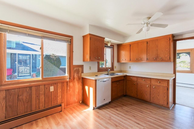 kitchen featuring plenty of natural light, white dishwasher, baseboard heating, and a sink