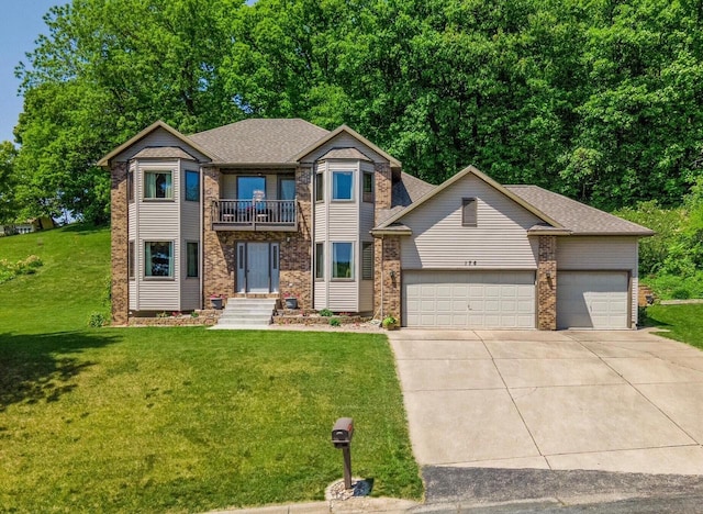 view of front of property with a front yard, a balcony, driveway, an attached garage, and brick siding