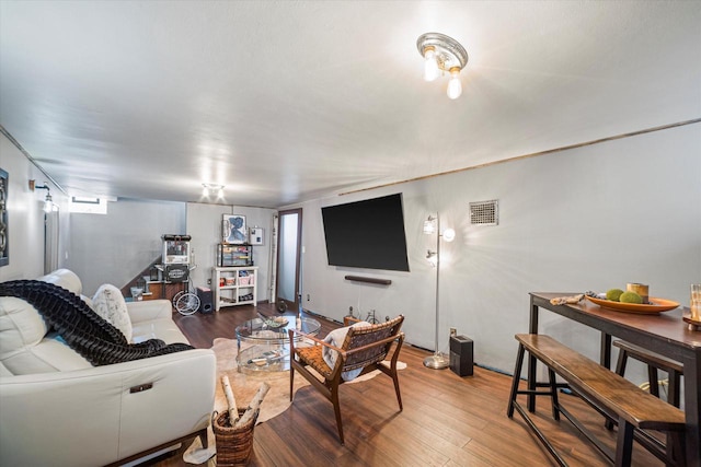 living area featuring stairway, wood finished floors, and visible vents