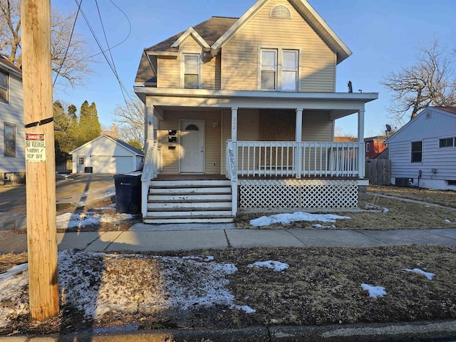 view of front of house featuring covered porch, a detached garage, and central AC unit