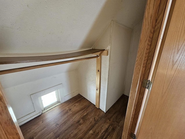 bonus room featuring dark wood finished floors and vaulted ceiling