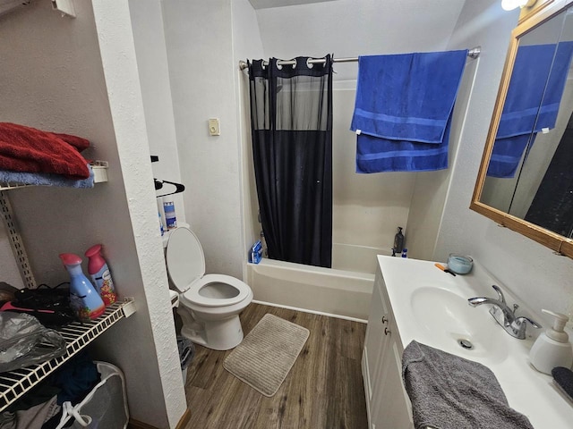 full bath featuring shower / bath combo with shower curtain, wood finished floors, toilet, and vanity