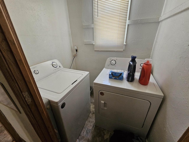 laundry room with independent washer and dryer, a textured wall, and laundry area