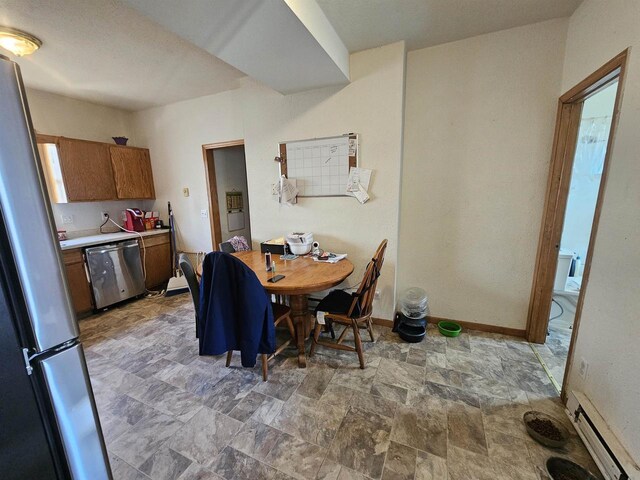 dining room featuring a baseboard radiator, stone finish flooring, and baseboards