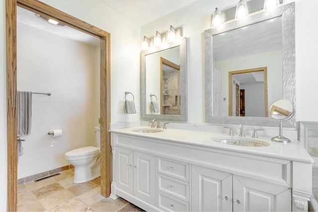 full bath with a sink, visible vents, toilet, and double vanity