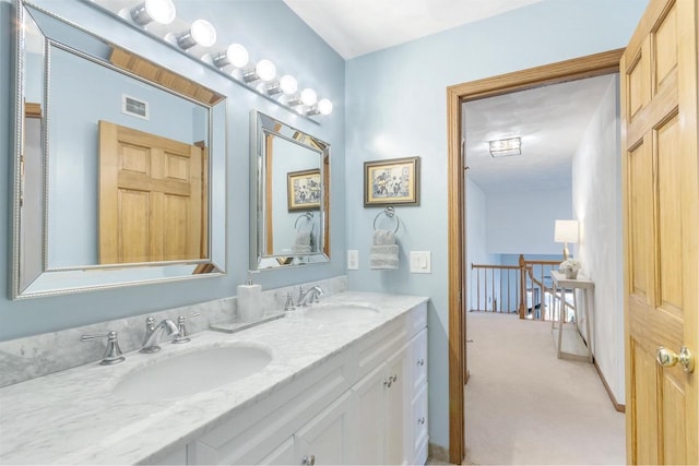 bathroom with double vanity, visible vents, and a sink