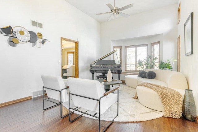 living room with visible vents, baseboards, and wood finished floors