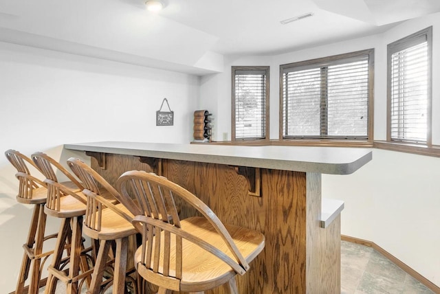 bar with visible vents, baseboards, and a dry bar