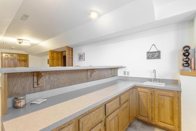 bar with light tile patterned floors, visible vents, lofted ceiling, and a sink