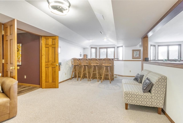 living area featuring a dry bar, baseboards, and a wealth of natural light