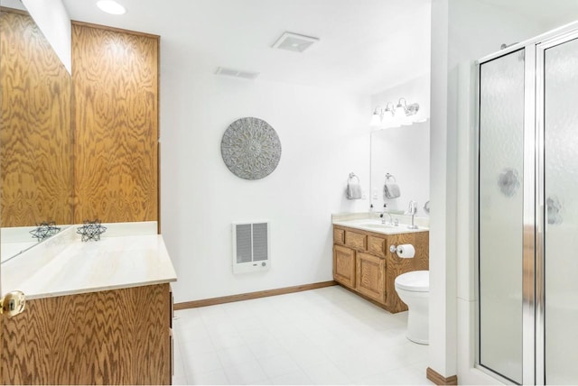 bathroom with vanity, toilet, baseboards, and a stall shower