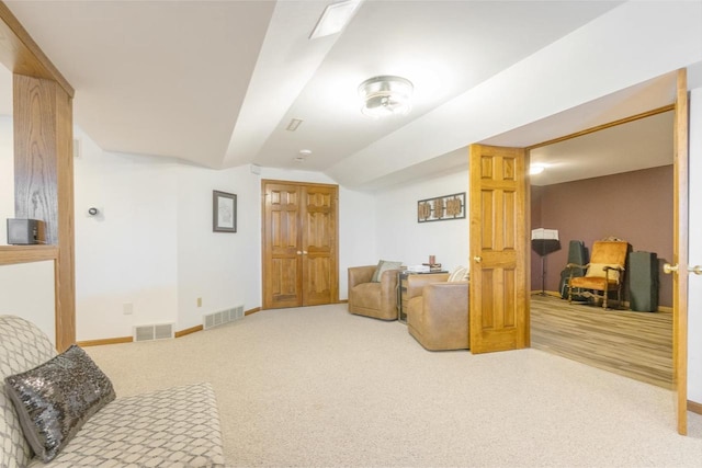 sitting room featuring carpet, lofted ceiling, baseboards, and visible vents